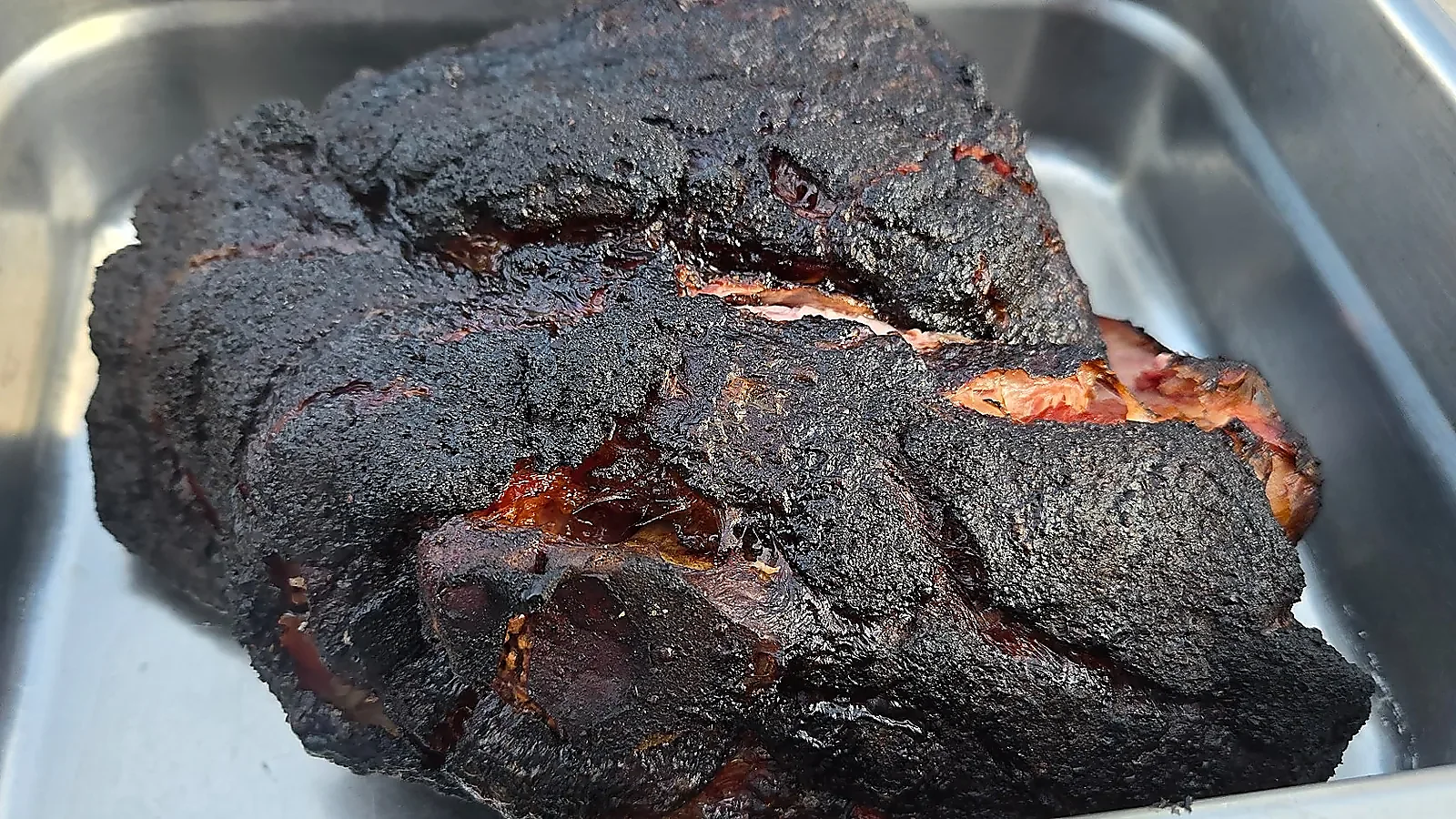 Smoked pork butt resting in pan after cooking