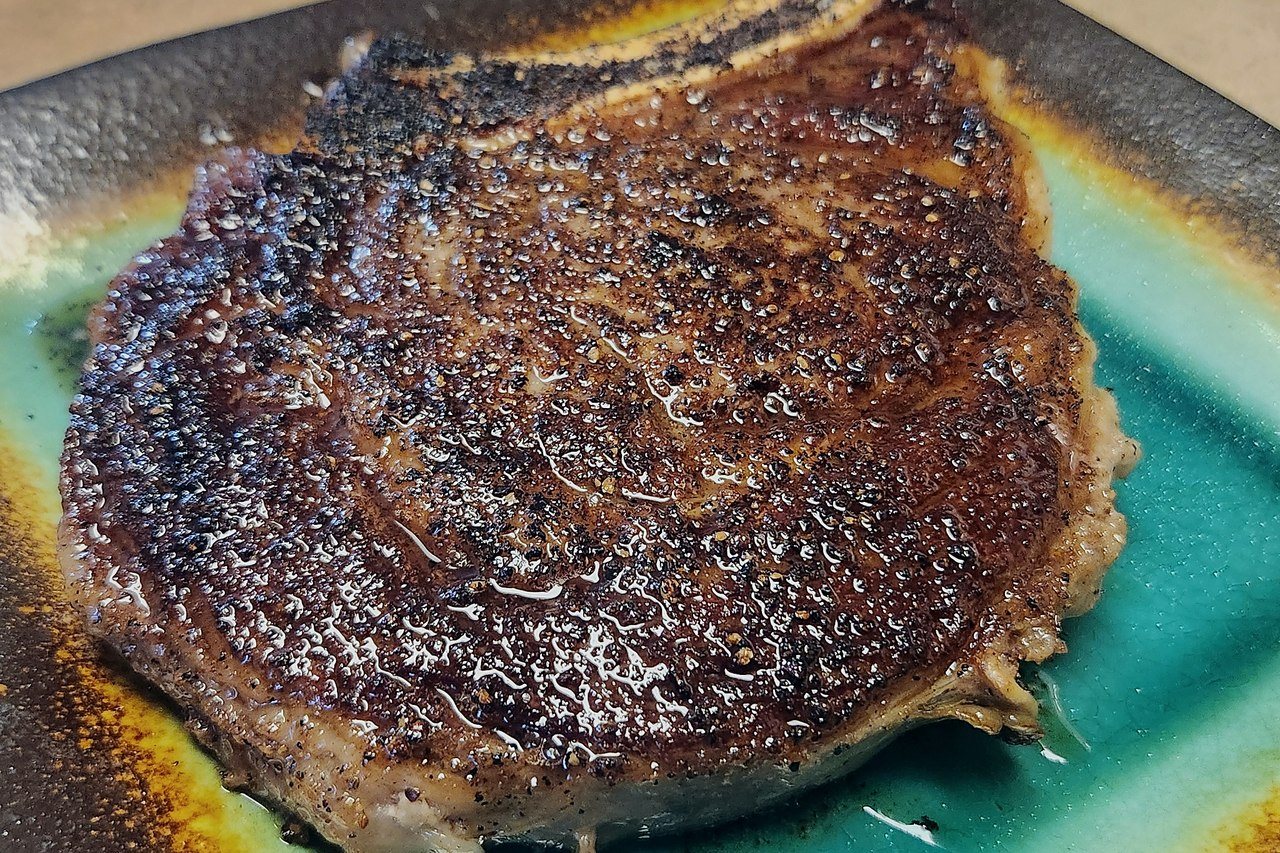 Close-up of steak slices with browned crust and visible juices.