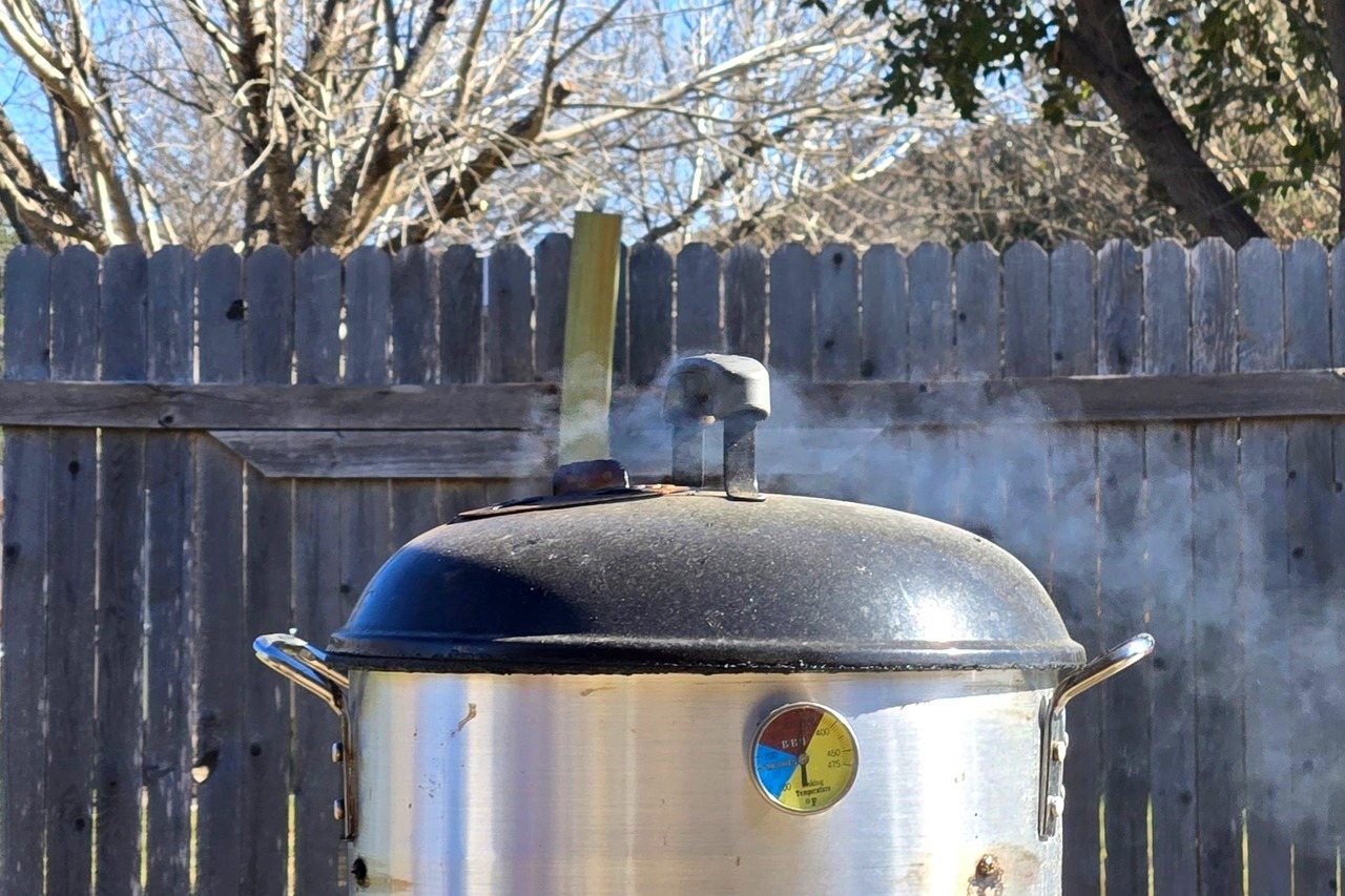 Light, thin smoke drifting from a smoker vent.